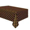Mantel de plástico negro con lunares naranjas